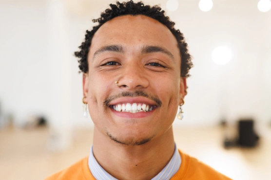 Smiling new patient welcomed to Rō Dental Studio for a comfortable, stress-free first dental visit in Calgary, AB.