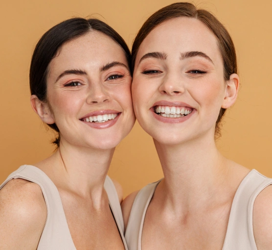 Smile Design at Ro Dental Studio Calgary – Two women smiling with perfect teeth