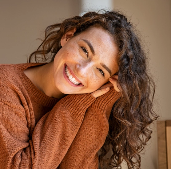 Smiling patient showing the natural-looking results of custom porcelain veneers at Rō Dental Studio in Calgary, AB.